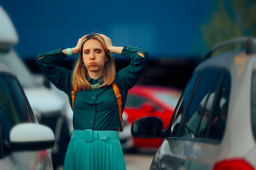 Stressed woman remain locked outside her vehicle in a parking lot
