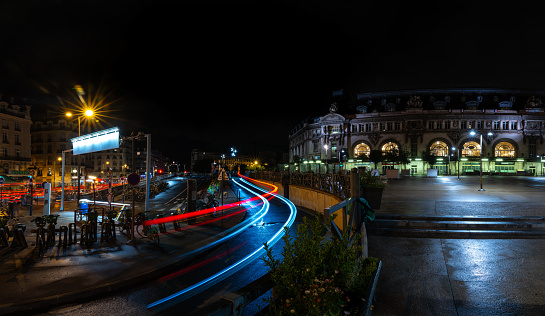 Low exposure photo with car lights leaving Paris Gare in Lyon at night. France. August 11, 2023