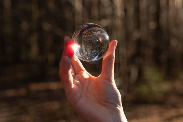 istock Glass transparent globe, sphere, ball in hand in nature. Vision concept 2147194310