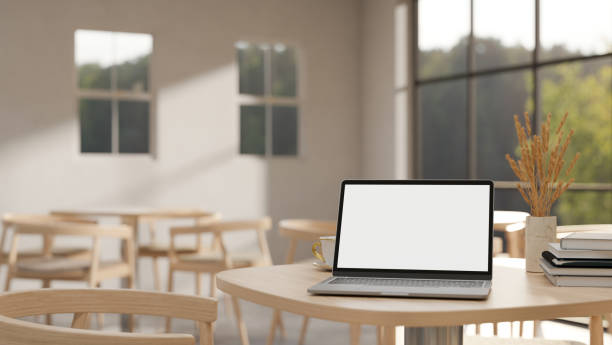 istock A white-screen laptop computer mockup on a wooden table in a minimalist comfortable coffee shop. 2147318023