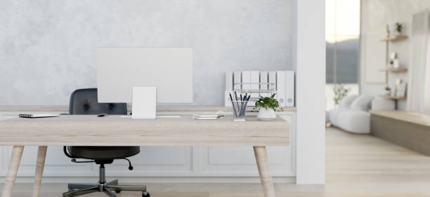 istock A contemporary white home office features a computer desk and a doorway through a living room. 2147319056