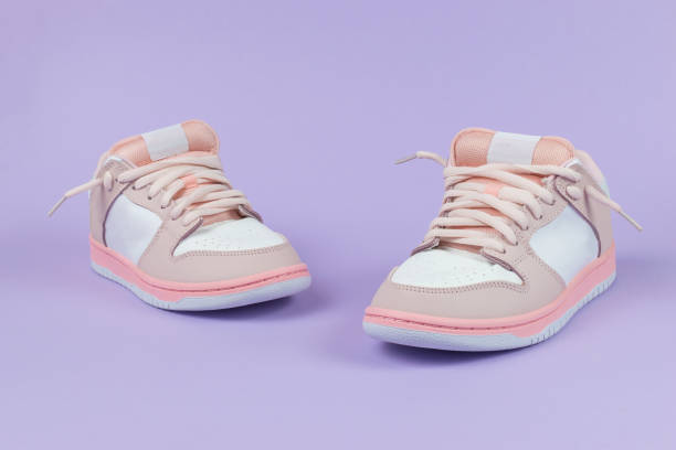 istock Sneakers are pink and white on a purple background. 2147357351