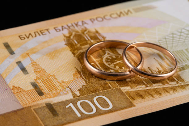 istock Wedding rings and a 100 Russian ruble banknote 2147397950