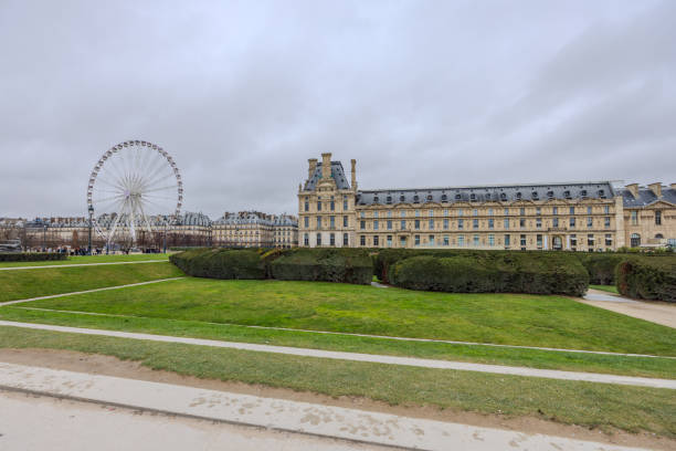 Paris, France - December 26, 2023:  Musee du Louvre and Ferris Wheel on a cloudy day.  HDR encoded