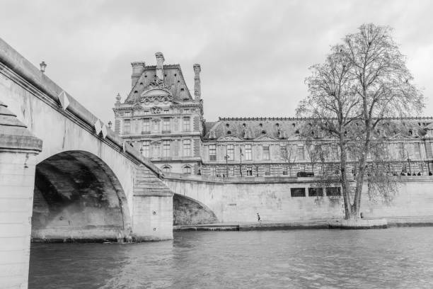 The City of Paris France on October 23, 2023:      Part of the facade of the Louvre Museum showing the umbrellas of the Le Café Marly in Paris France