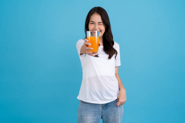 istock Beautiful woman drinking orange from a glass 2147486437