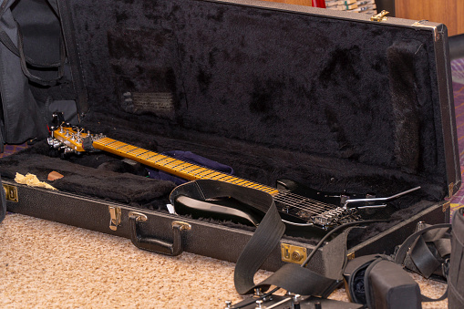 Black guitar with tremolo in a hard case