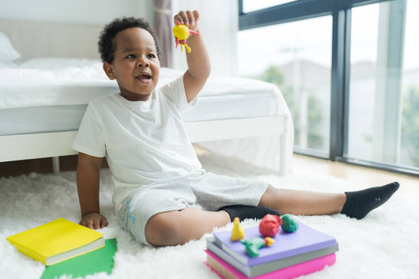 istock Cute little boy making things from plasticine on the ground Follow your imagination with a smiling. 2147488066