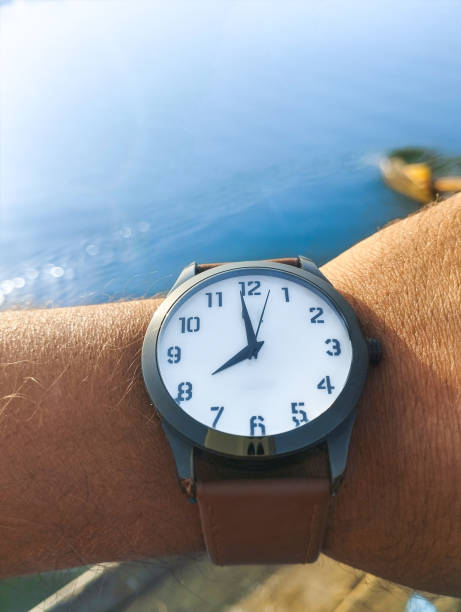close up of a watch with a brown leather strap hand.