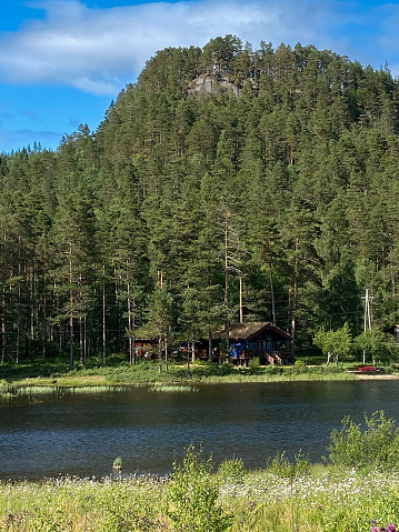 typical wooden log cabin in Norway in the forest by the lake