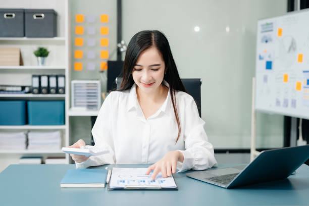 istock Asian businesswoman working with working notepad, tablet and laptop documents talking on the smartphone, tablet and laptop video call tax 2147499112