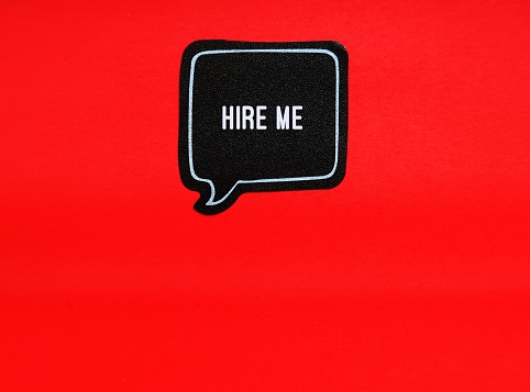 Sticker on red copy space background written HIRE ME - concept of person in job hunting or job seeking search for employment - looking for a job