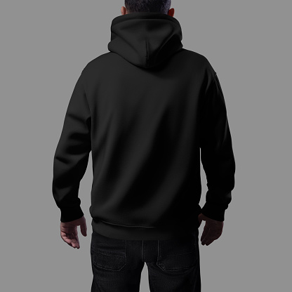 Mockup of a black oversized hoodie on a man in dark jeans, close-up rear view, loose clothes for design, branding, advertising. Texture streetwear template, male apparel isolated on background
