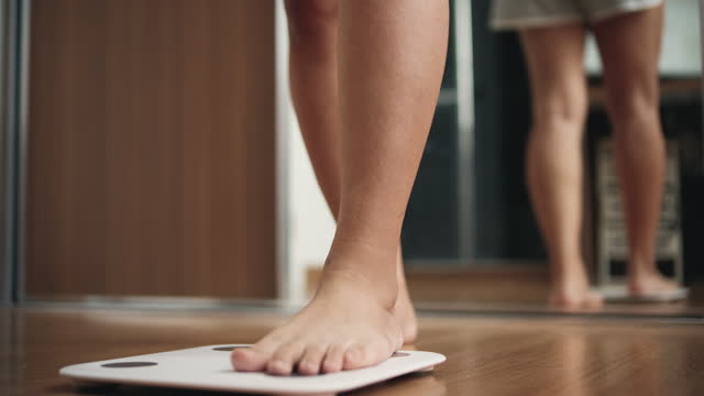 Overweight female stepping onto scale