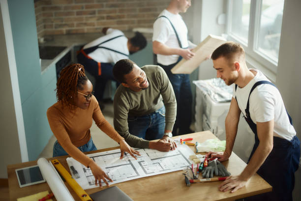 istock Above view of black couple analyzing plans with their manual worker. 2147500615