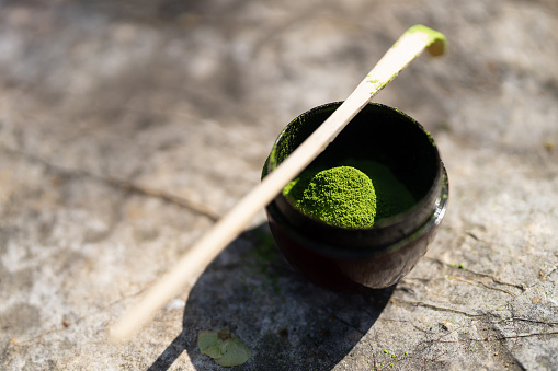 The matcha tea powders is in a bowl and there is an Chasaku or bamboo matcha spoon which is used to scoop the perfect amount of matcha powder