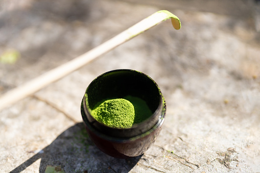 The matcha tea powders is in a bowl and there is an Chasaku or bamboo matcha spoon which is used to scoop the perfect amount of matcha powder