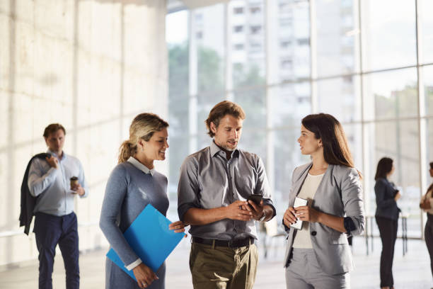 istock Business colleagues using mobile phone in a hallway. 2147505022