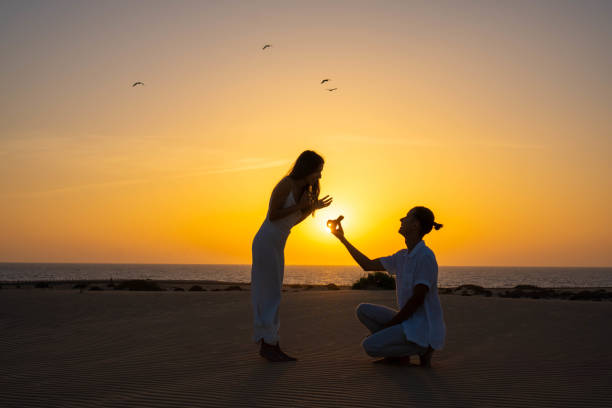 Romantic beach marriage proposal at sunset