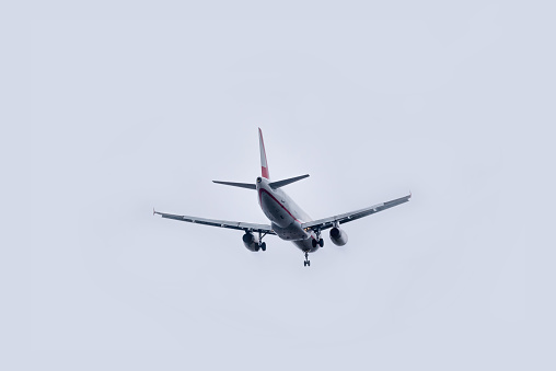 Commercial airplane flying against overcast sky