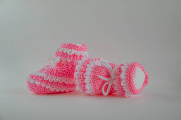 istock Pink knitted baby booties socks on white background 2147506466