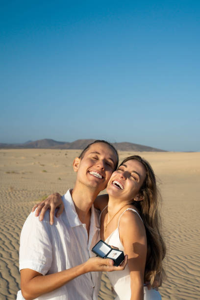 istock Joyful couple with engagement ring in desert 2147506655