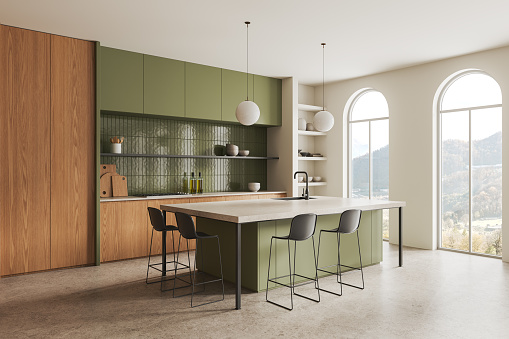 Corner view of green home kitchen interior with bar counter, sink and stove, dishes and plates on shelf. Cooking space in modern apartment with panoramic arched window. 3D rendering