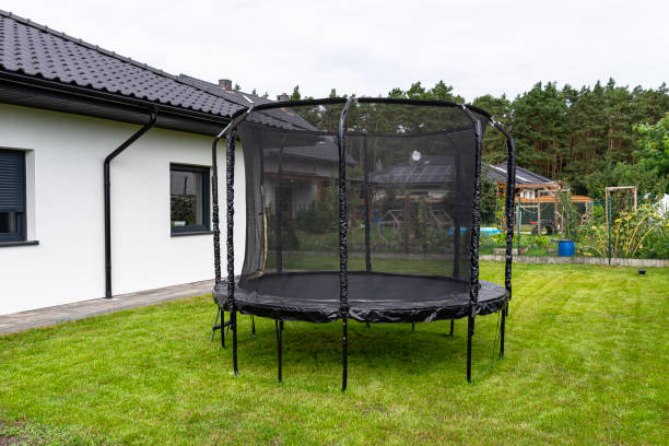 istock Large childrens jumping trampoline with protective net and closed zipper, standing in the garden. 2147511523
