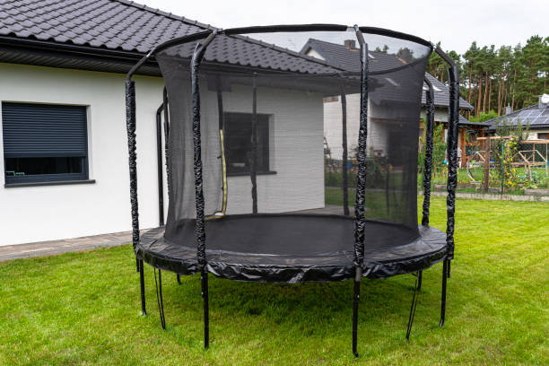 istock Large childrens jumping trampoline with protective net and closed zipper, standing in the garden. 2147511588