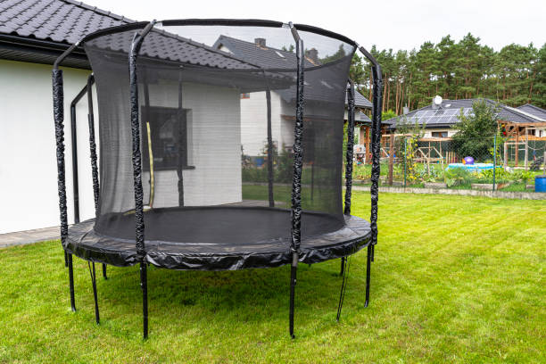 istock Large childrens jumping trampoline with protective net and closed zipper, standing in the garden. 2147511765