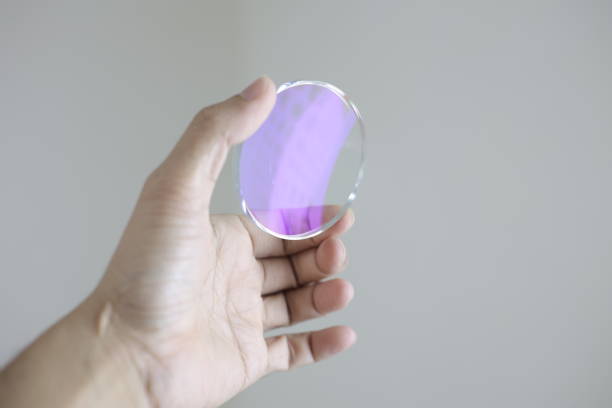 Hand holding glasses lenses in optical store
