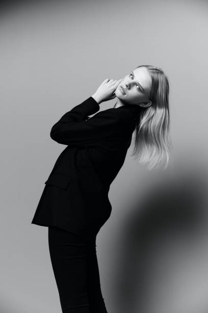 istock Charming young professional model puts her hand to her face cheek in the studio. The concept for the new collection. Classic black and white photo 2147514682
