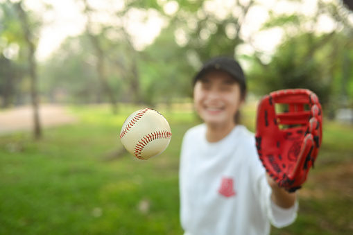 School girl in baseball glove catching a ball. Sports and youth lifestyle concept.