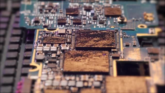 Microchips tracking shot, in gold light, melted circuit board surface