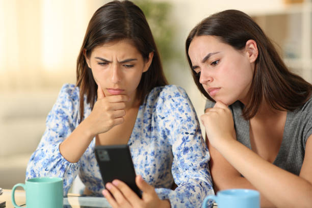 istock Confused friends watching media content on phone 2147517082