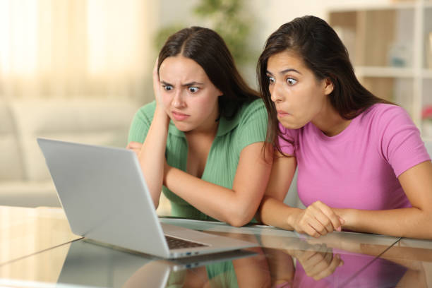 istock Perplexed friends watching media on laptop at home 2147517174