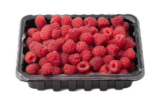 Raspberry in a container isolated on a white background. Close-up.