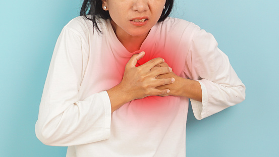 Woman chest pain with Concerned Expression on blue background