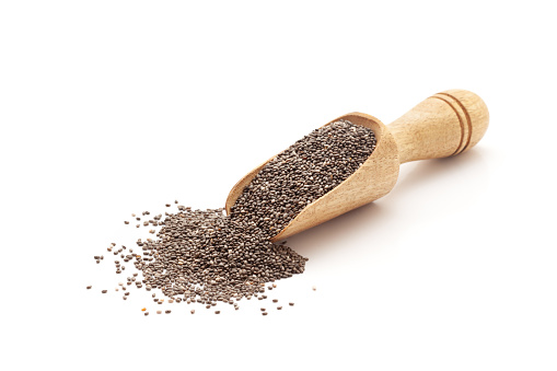 Front view of a wooden scoop filled with Organic Chia Seeds (salvia hispanica). Isolated on a white background.