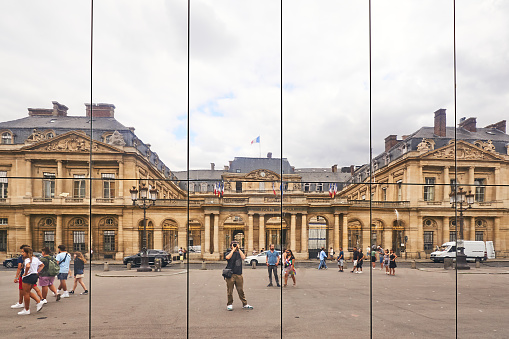 Paris, France - July 13, 2024: Reflection of the Conseil d'État in the glass facade of the Architecture Jean Nouvel / chantier Fondation Cartier building.