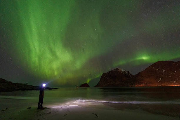 istock Lone man on the beach under northern lights, Norway 2147518325