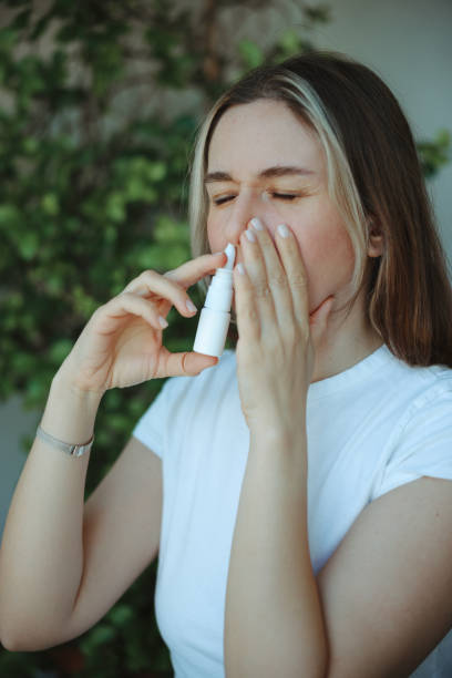 istock Woman is having flu and she is using nasal spray to help herself. 2147518375