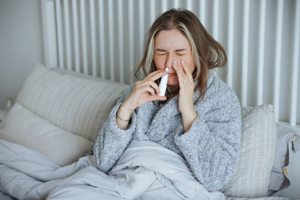istock Sick young woman using nasal spray 2147518504