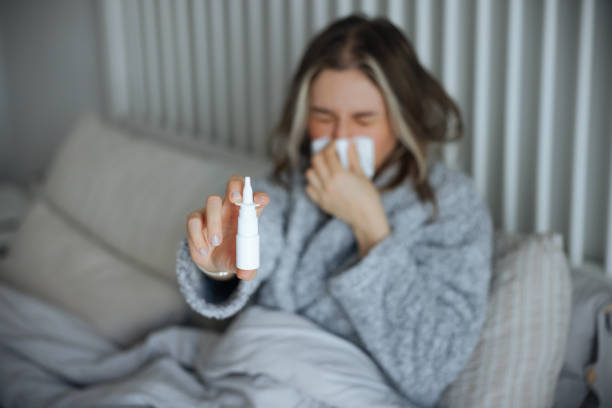 istock Sick young woman using nasal spray 2147518588