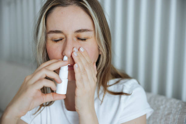 istock Sick young woman using nasal spray 2147518608