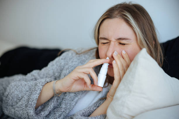 istock Sick young woman using nasal spray 2147518632