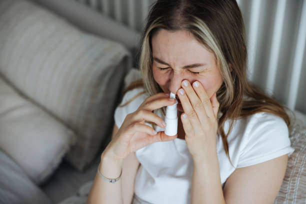 istock Sick young woman using nasal spray 2147519348
