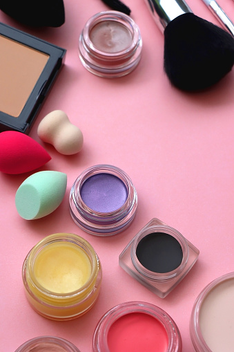 Various colorful beauty products on bright pink background. Selective focus.