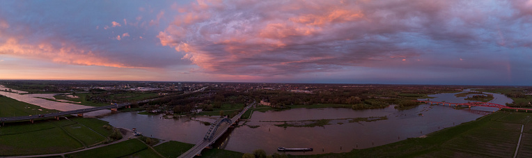 Amazing colorful sunset over the river IJssel in Overijssel, Netherlands during springtime seen from above. The strong colors in the sky are partly caused by the southern wind bringin sand from the Sahara desert over the European contintent.
