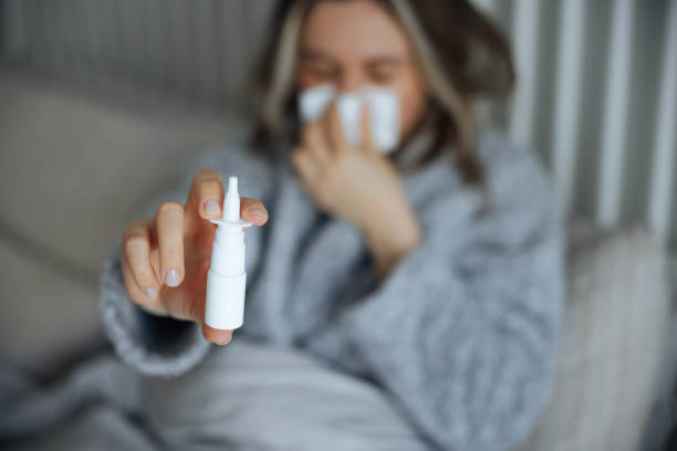 istock Sick young woman using nasal spray 2147519537